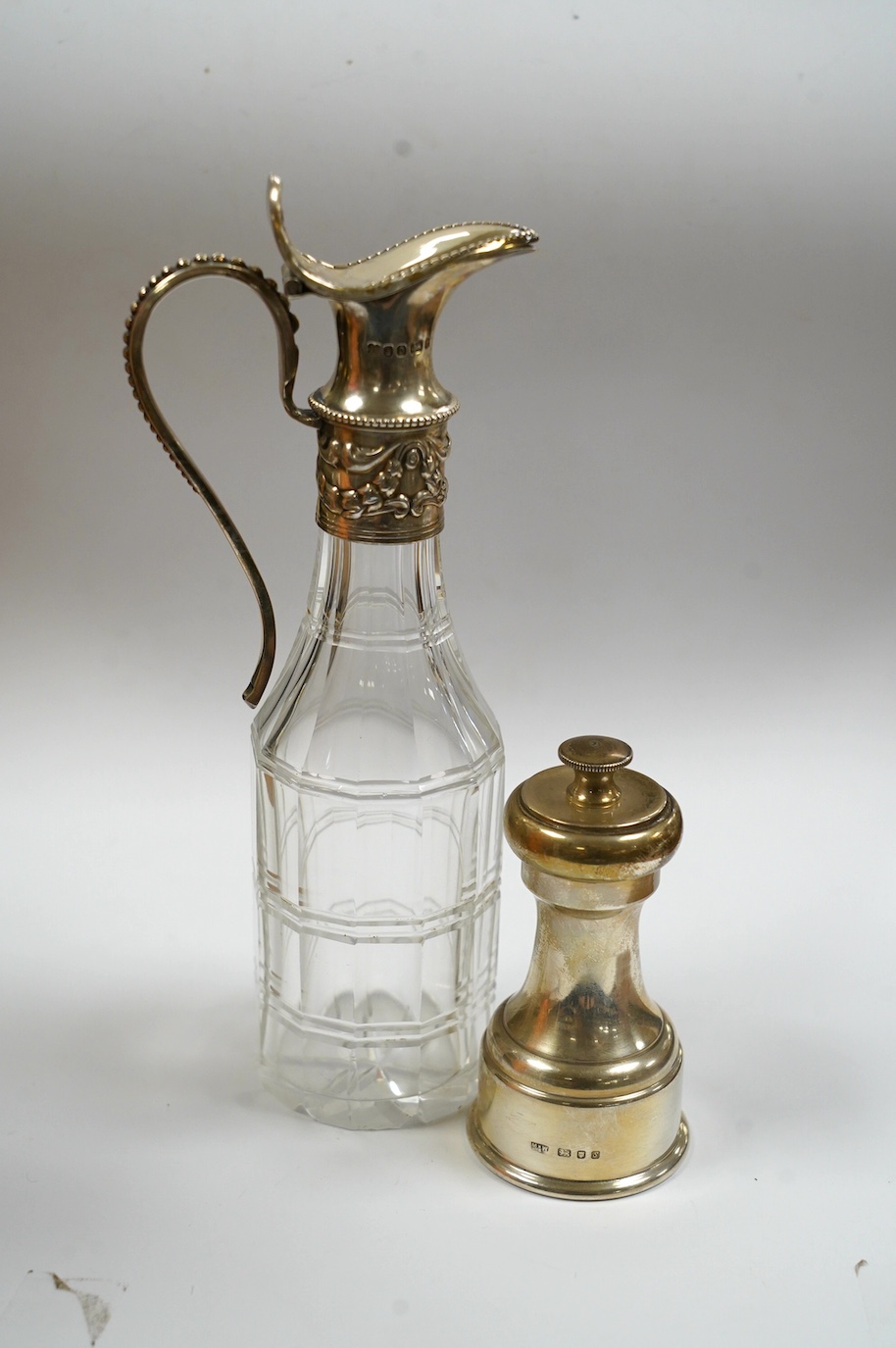 A modern silver mounted pepper mill, London, 1973, 86mm and a Victorian silver mounted glass vinegar bottle. Condition - poor to fair